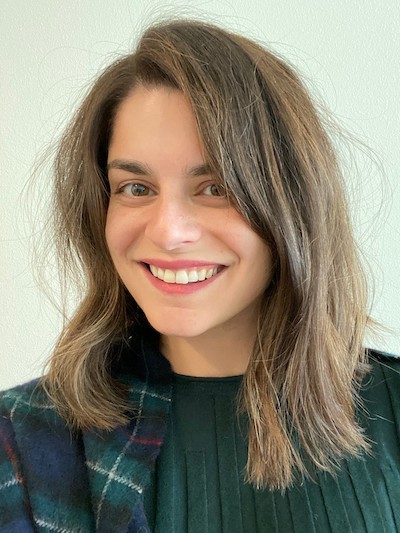 Photo of Christina McHugh smiling at the camera and wearing a green shirt. 